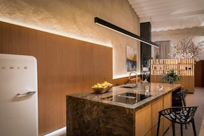 A modern kitchen with a built-in island, a refrigerator, and a wooden cabinet.