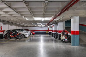A multi-level parking garage with several cars and motorcycles parked.