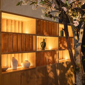 A wooden shelf unit with multiple compartments, some containing decorative vases.