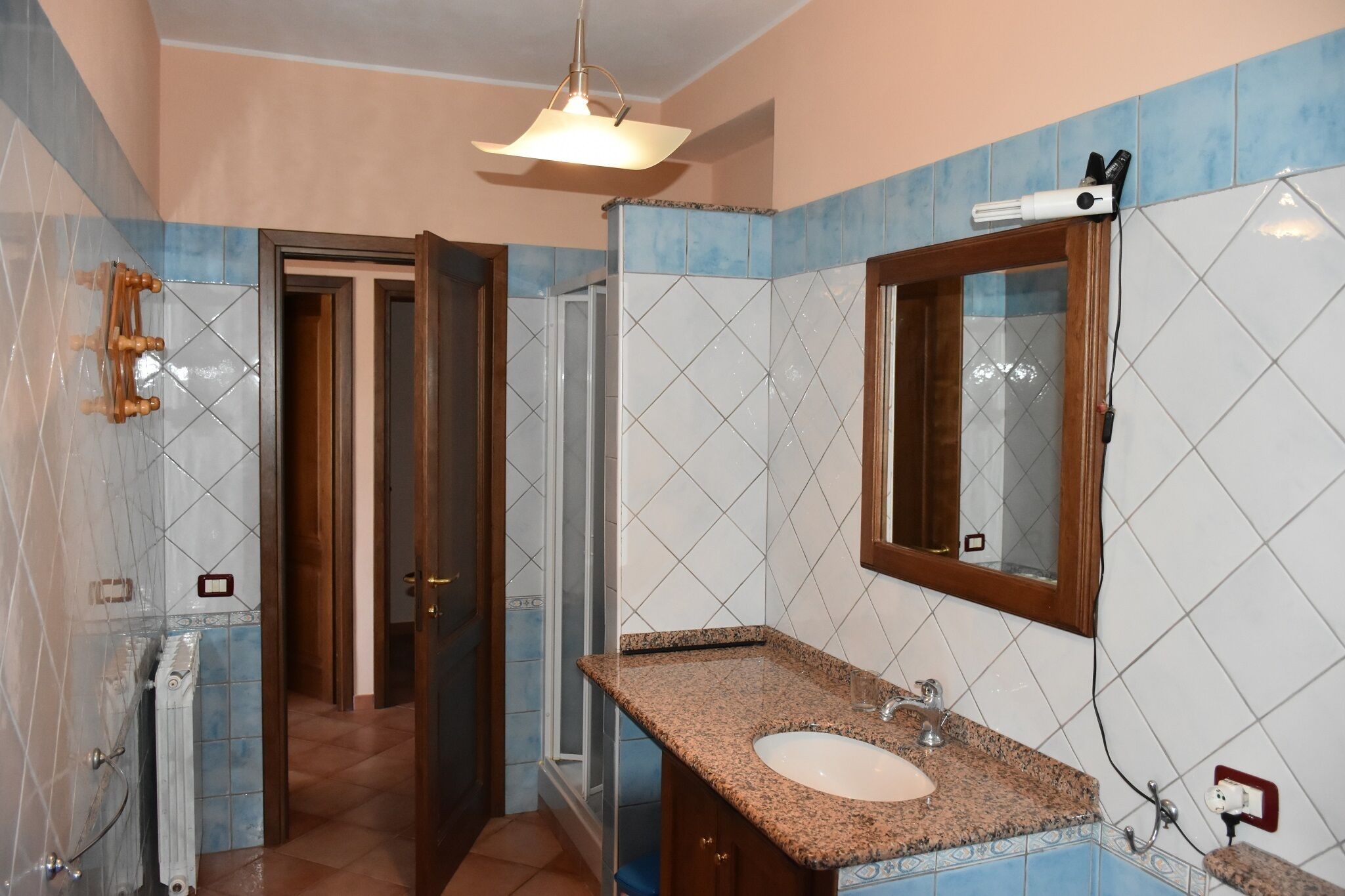 A bathroom with a sink, mirror, and shower.