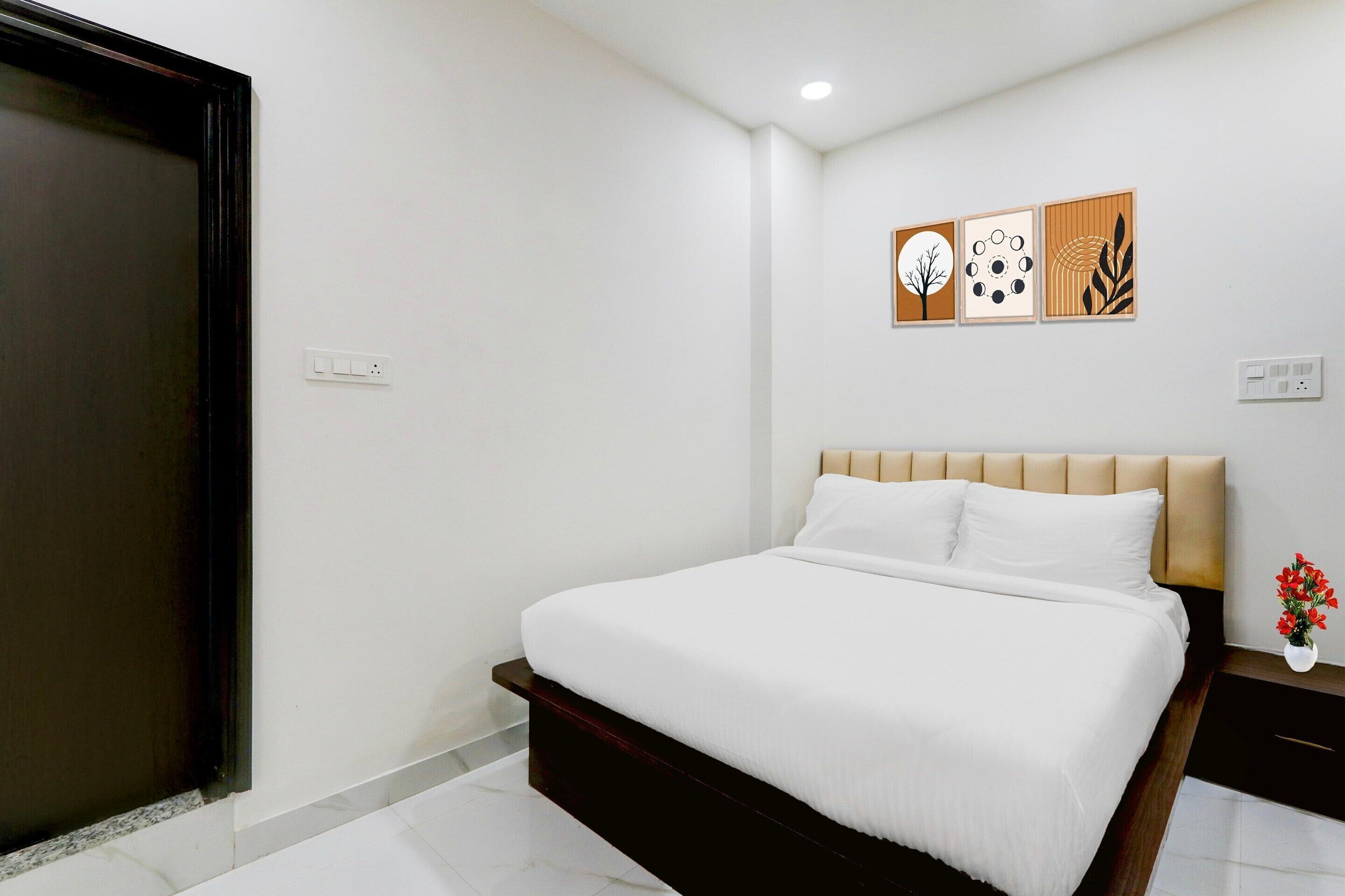 Ein Schlafzimmer mit Bett, Nachttisch, Wandbild und Tür.