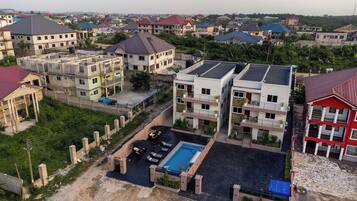 A residential area with multiple two-story houses, a swimming pool, and a gated entrance.