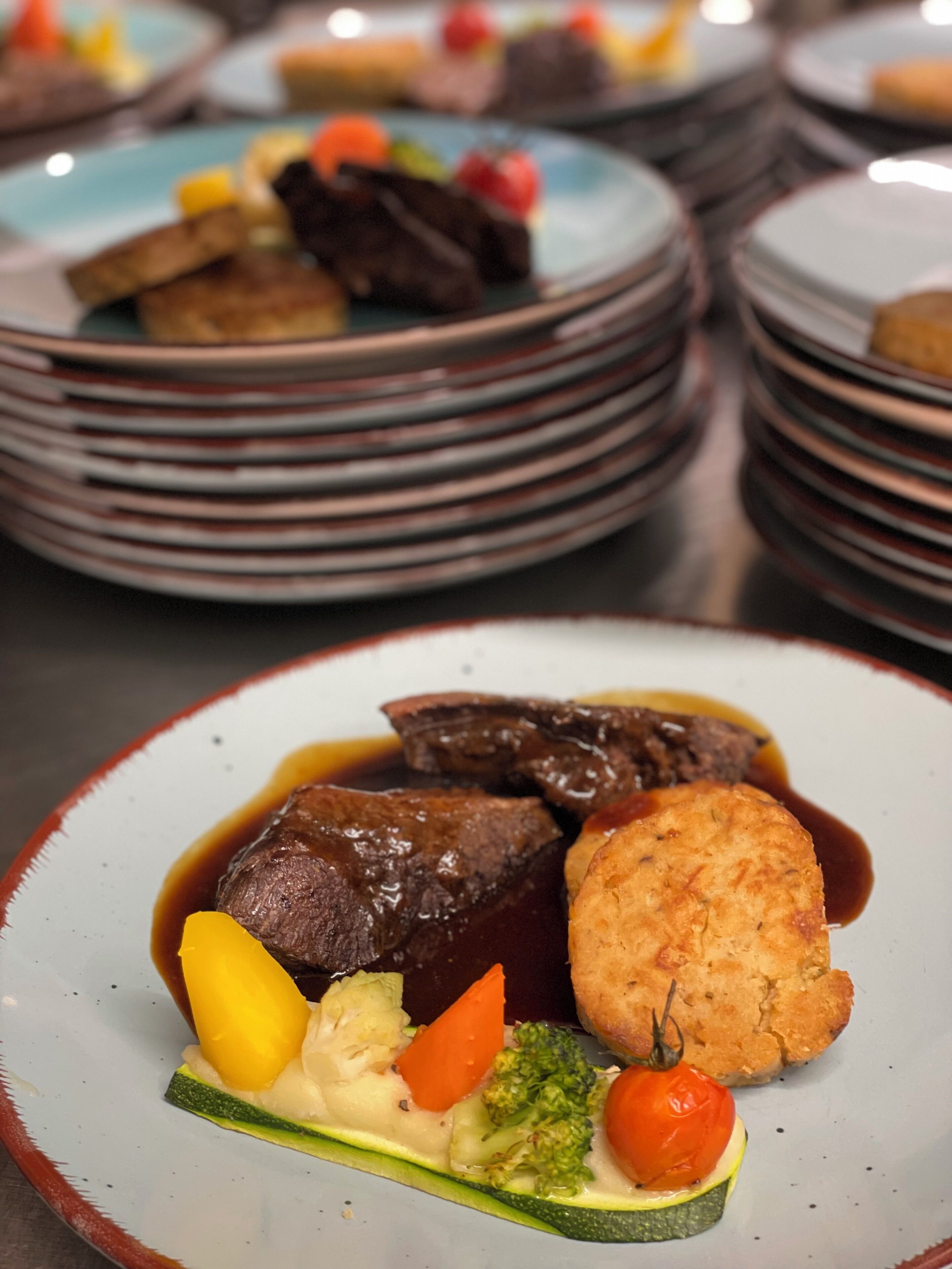 Une table à manger sur laquelle on trouve de nombreuses assiettes remplies de nourriture, notamment une variété de plats tels que de la viande, des légumes et une préparation cuite au four.