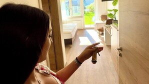 Habitació amb llit, televisió i finestra que ofereix vistes a vegetació.