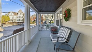 A covered porch with a bench, a decorative wreath, and a view of the street. - 3BR Salem Townhouse Minutes to downtown (Salem)