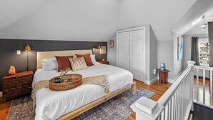A bedroom with a bed, nightstands, a wardrobe, and a staircase. - 3BR Salem Townhouse Minutes to downtown (Salem)