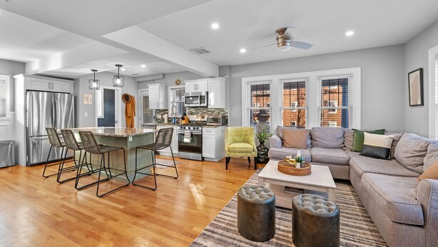 A spacious living area with a kitchen, wooden flooring, and a grey sofa. - 3BR Salem Townhouse Minutes to downtown (Salem)