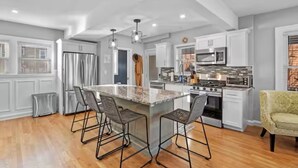 A modern kitchen with a central island, stainless steel appliances, and bar stools. - 3BR Salem Townhouse Minutes to downtown (Salem)