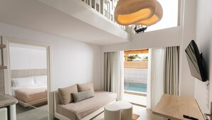 Een moderne hotelkamer met een bed, bank, ronde tafel en een televisie.