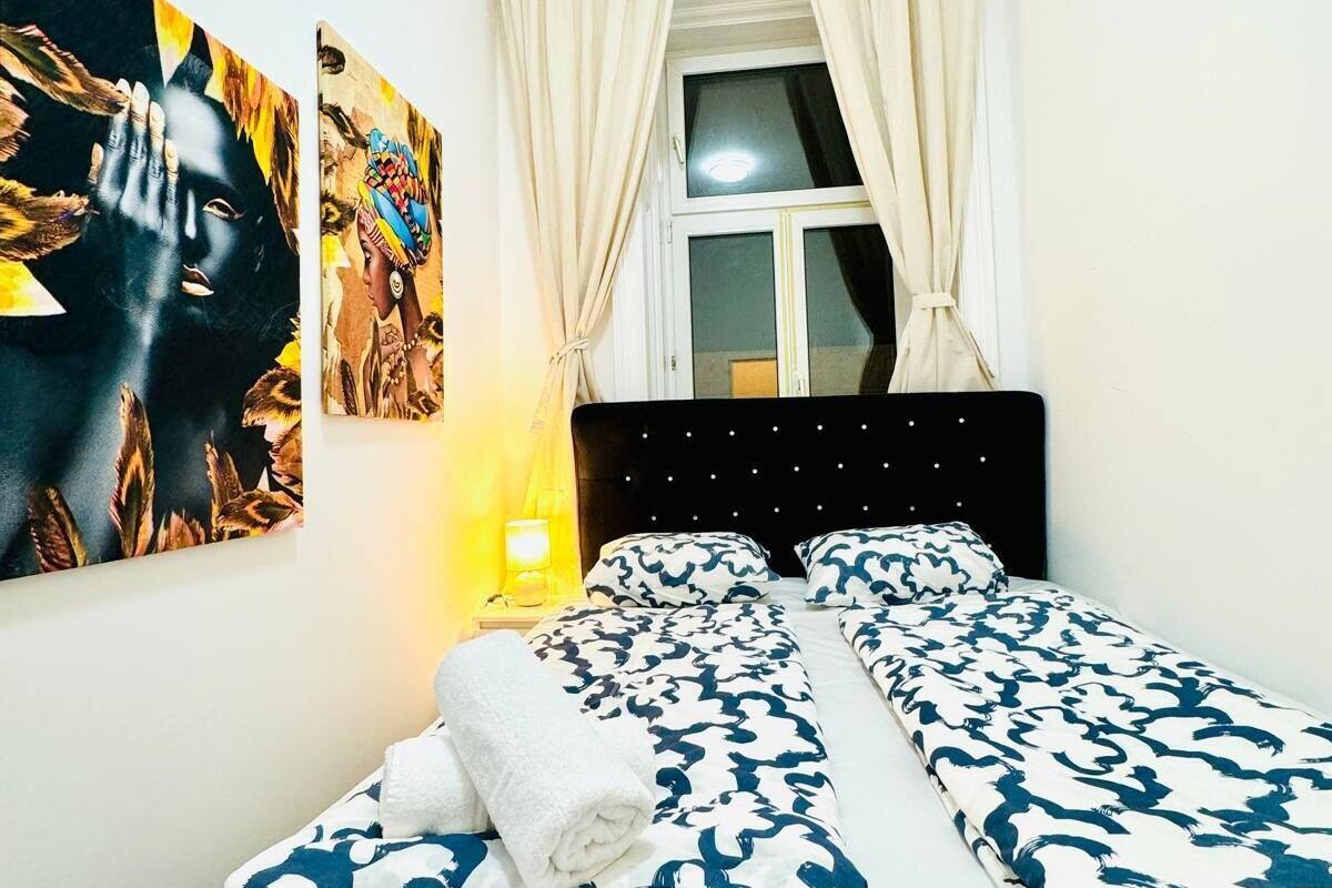 Ein Schlafzimmer mit Bett, Nachttisch und einem Fenster mit Vorhängen.