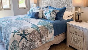 A bedroom with a bed, nightstands, a ceiling fan, and a window with blinds. - Bella Sirena (Puerto Peñasco)