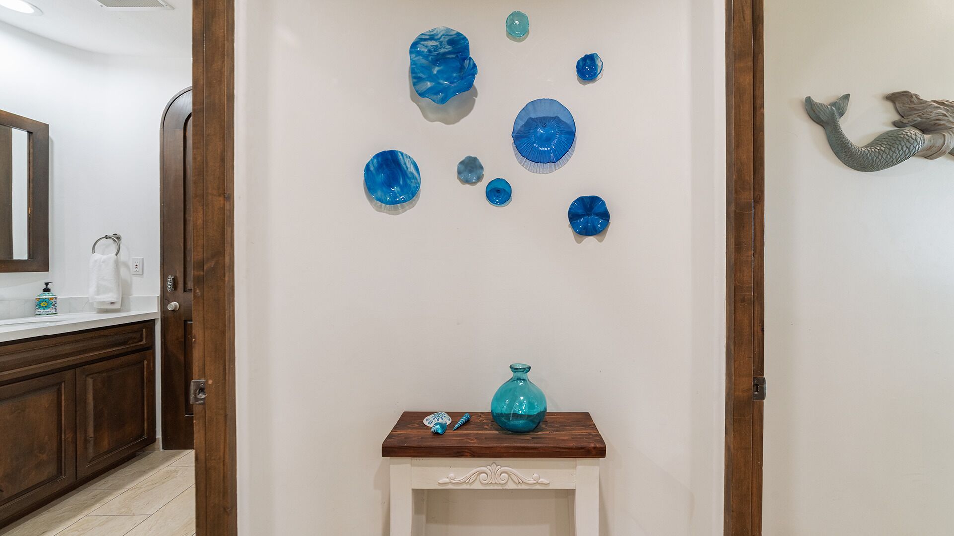 Un bagno con un mobile lavabo in legno, un lavandino bianco e uno specchio.