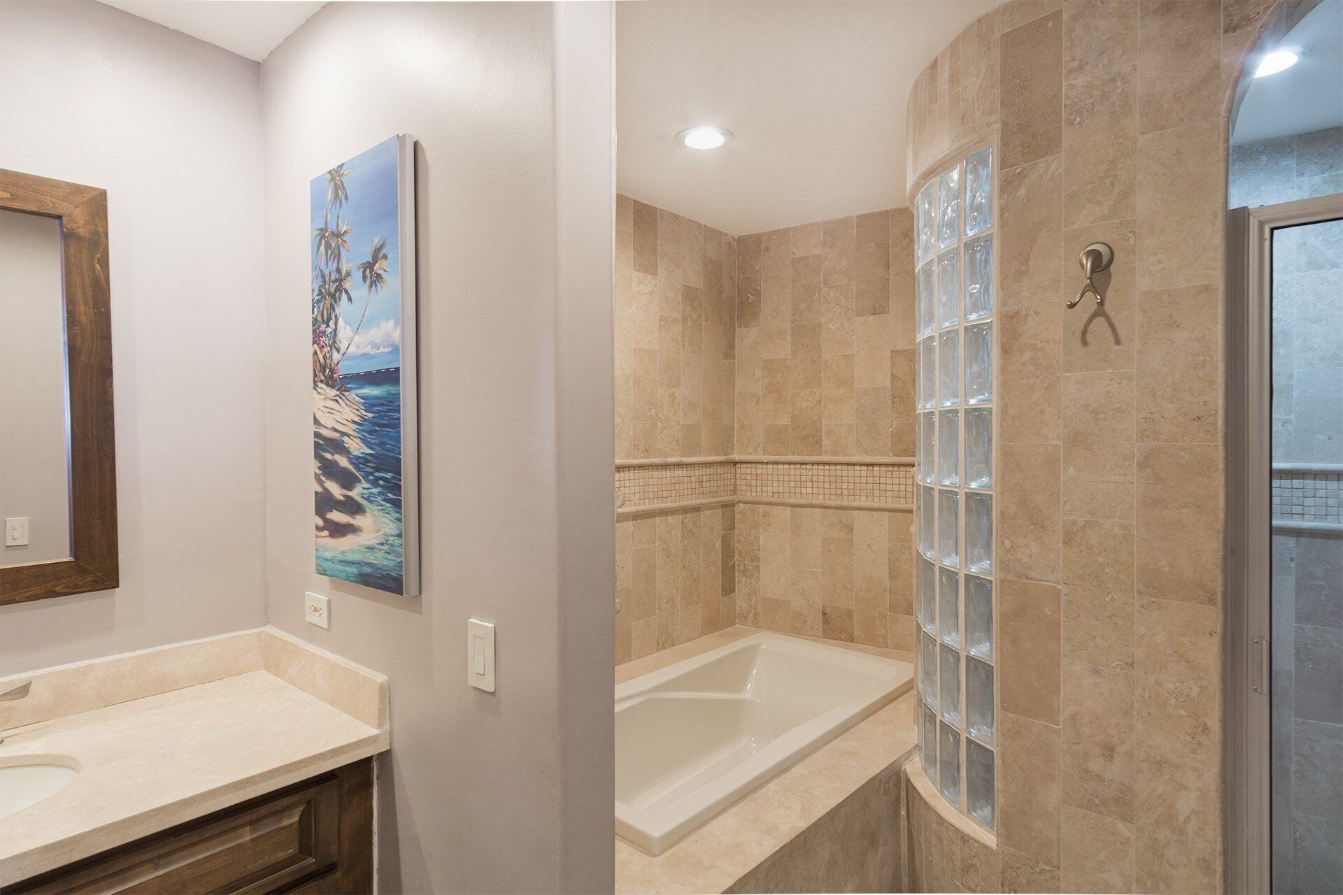 A bathroom with a bathtub, a shower, and a glass-enclosed window.