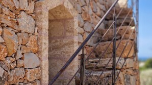 Eine Steinmauer mit einem Metallgitter.