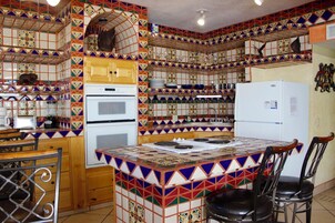 A kitchen with a tiled backsplash, wooden cabinets, a stove, and a refrigerator.