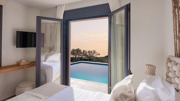 Ein Schlafzimmer mit großem Fenster, einem Bett, einem Nachttisch und einem Fernseher.