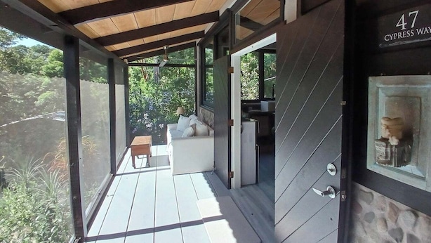 A covered outdoor area with a wooden ceiling, a sofa, and a small table. A door labeled "47" is visible. - Escape to Luxury in the Cangrejal River Valley – A Jungle Retreat Awaits! (Atlántida Department)
