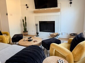 Smart-tv, een open haard, boeken en een computerscherm