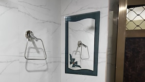 Une salle de bain avec un lavabo blanc, un miroir et un porte-serviettes.