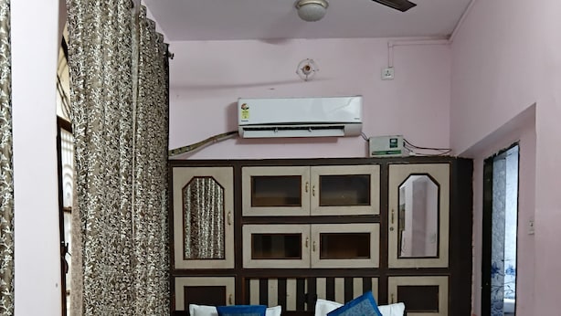 Une chambre à coucher avec un lit, un ventilateur de plafond, un appareil de climatisation et une fenêtre donnant sur un beau paysage.