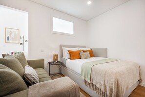 A modern bedroom with a bed, a sofa, and a small table. - Matosinhos Seaside Prime Studio (Matosinhos)