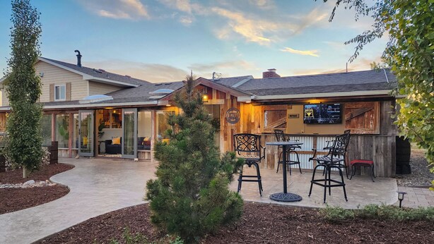 A patio area with outdoor seating, a bar, and a small tree.