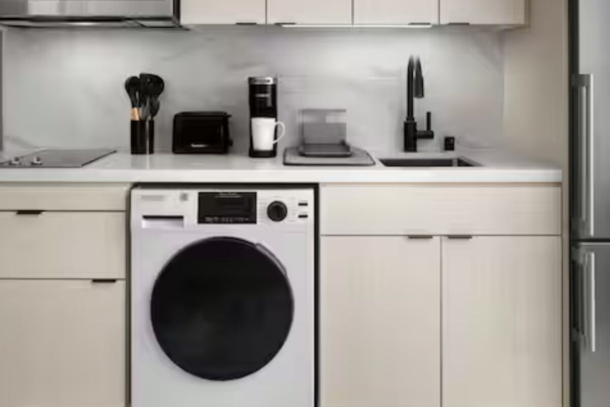 Una cocina compacta con lavavajillas, cafetera y refrigerador.