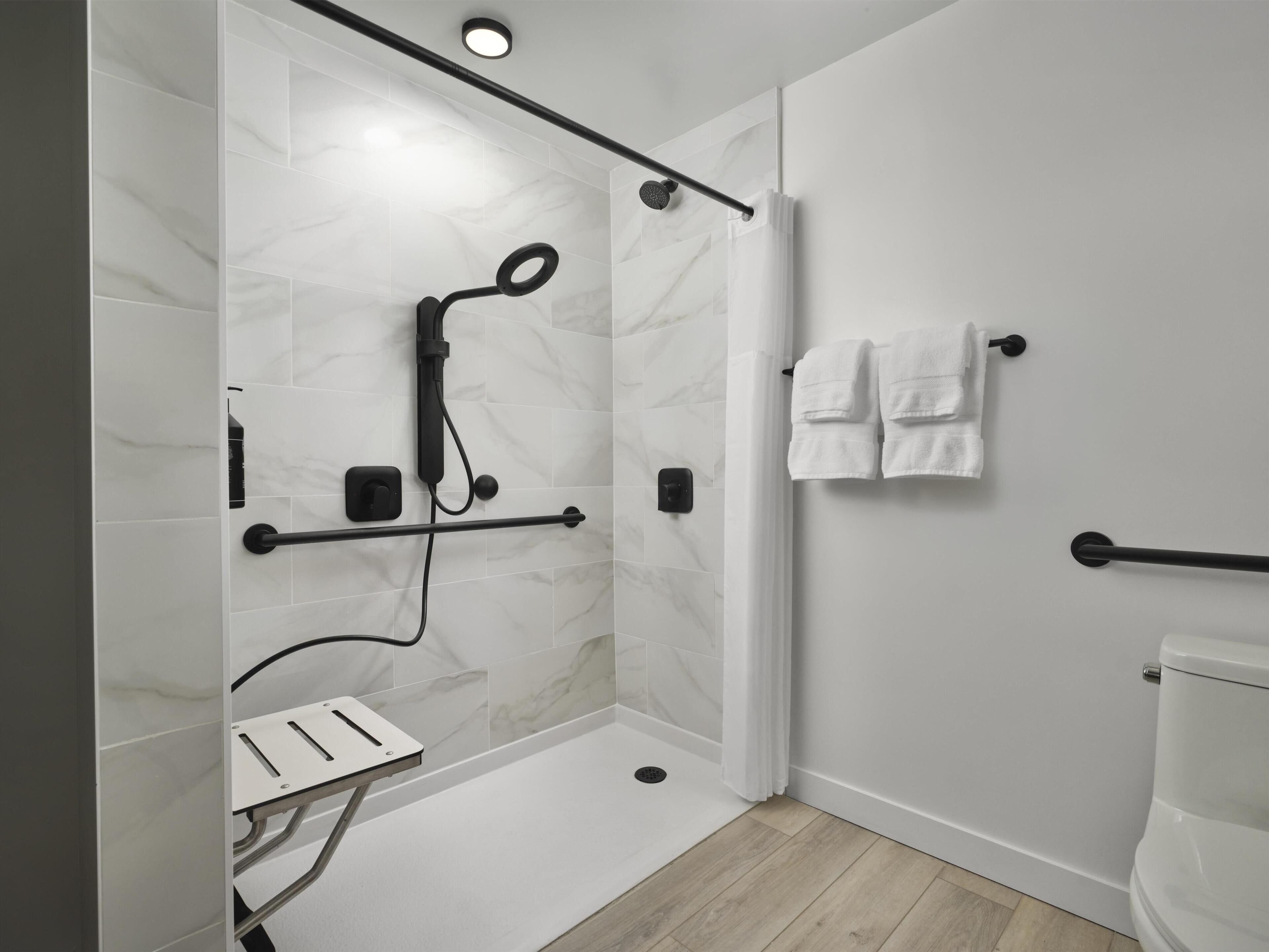 Ein modernes Badezimmer mit Dusche, Toilette und Handtuchhalter.