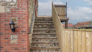 A stone staircase leading to a wooden deck with a metal railing. - The Hayloft (Richmond)