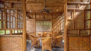 A room with a bamboo ceiling, woven walls, and a central table with chairs. - Tabao Garden (Chongqing)