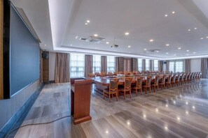 A conference room with a long table, chairs, a podium, and a large screen. - Tabao Garden (Chongqing)