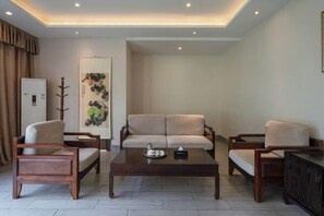 Una sala de estar moderna con un sofá, dos sillones, una mesita de centro y un aparador.