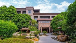 A modern building with a traditional pavilion in a landscaped garden. - Tabao Garden (Chongqing)