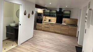 Eine moderne Küche mit Holzausstattung, einem eingebauten Ofen und einer Mikrowelle.