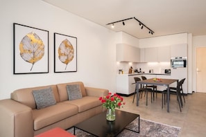 A modern living room with a sofa, coffee table, and artwork on the wall.