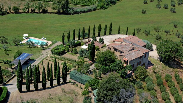 Una extensa propiedad con piscina, paneles solares y un jardín bien cuidado.