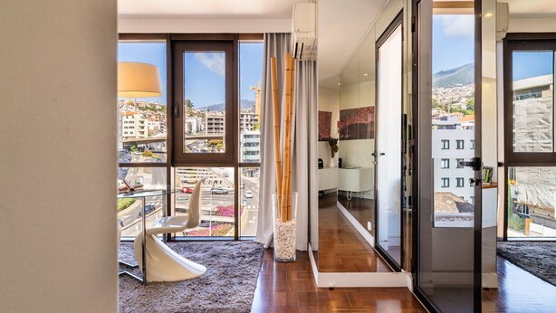 Un appartement moderne avec de grandes fenêtres, un toboggan et une vue sur la ville.