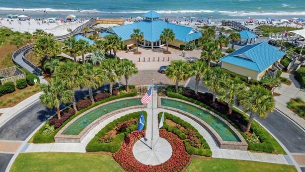 A coastal resort with a central courtyard, palm trees, and a view of the beach. - Family-friendly Villa by Ocean.  Walk to beach, bike, golf, tennis, fish & pool. (Pawleys Island)