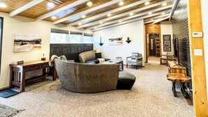 A spacious living area with a high wooden ceiling, a curved sofa, and a fireplace. - MY PLACE! Luxury 2 Bed with piano! (Willmar)