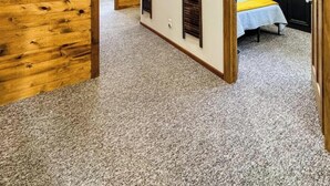 A room with wooden walls and ceiling, a bed with a striped bedspread, and a painting on the wall. - MY PLACE! Luxury 2 Bed with piano! (Willmar)