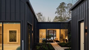 Una casa moderna con piscina, terrazza in legno e vista sul giardino.