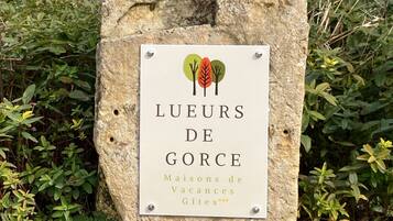 A sign with the text "LUEURS DE GORCE" and "Maisons de Vacances Gîtes".