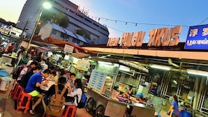 A busy street food market with people eating and vendors selling food. - TwinTrees Kelawai (George Town)