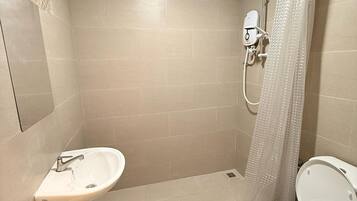A bathroom with a shower, toilet, and sink.