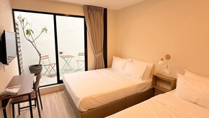 A hotel room with two beds, a desk, and a chair. - TwinTrees Kelawai (George Town)