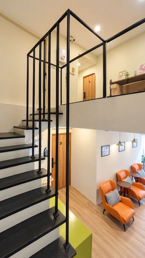 A modern interior with a black metal staircase leading to a second-floor area. - TwinTrees Kelawai (George Town)