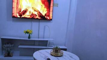 Deluxe-Apartment, Stadtblick | Wohnbereich | 24-Zoll-Smart-TV mit Digitalempfang