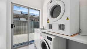 A laundry room with a washing machine, dryer, and a sink. - 29 Blanche Pd, Hindmarsh Island (Hindmarsh Island)