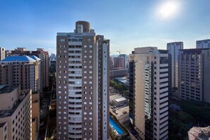 A high-rise building with multiple floors, surrounded by other tall buildings, and a clear sky.