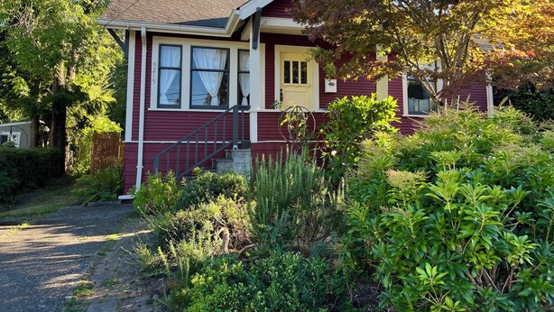 A single-story house with a front porch, a chimney, and a number '5215' on the wall. - Charming 2-bedroom bungalow in Seward Park (Seattle)